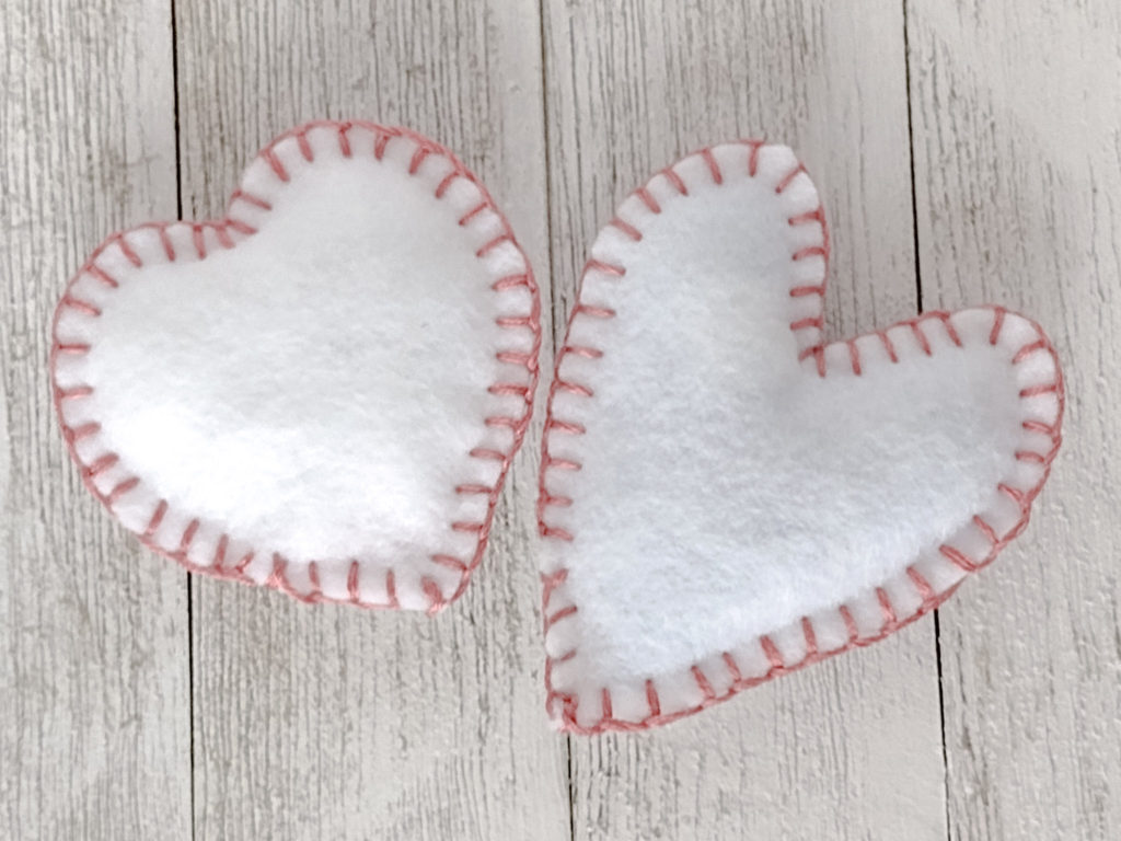 Two white felt stuffed Valentines day hearts