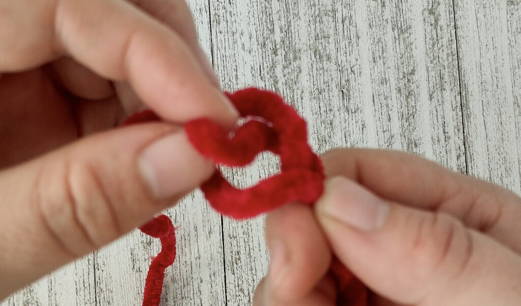 Yarn loop with a piece of yarn coming up through the loop for easy DIY finger knitting